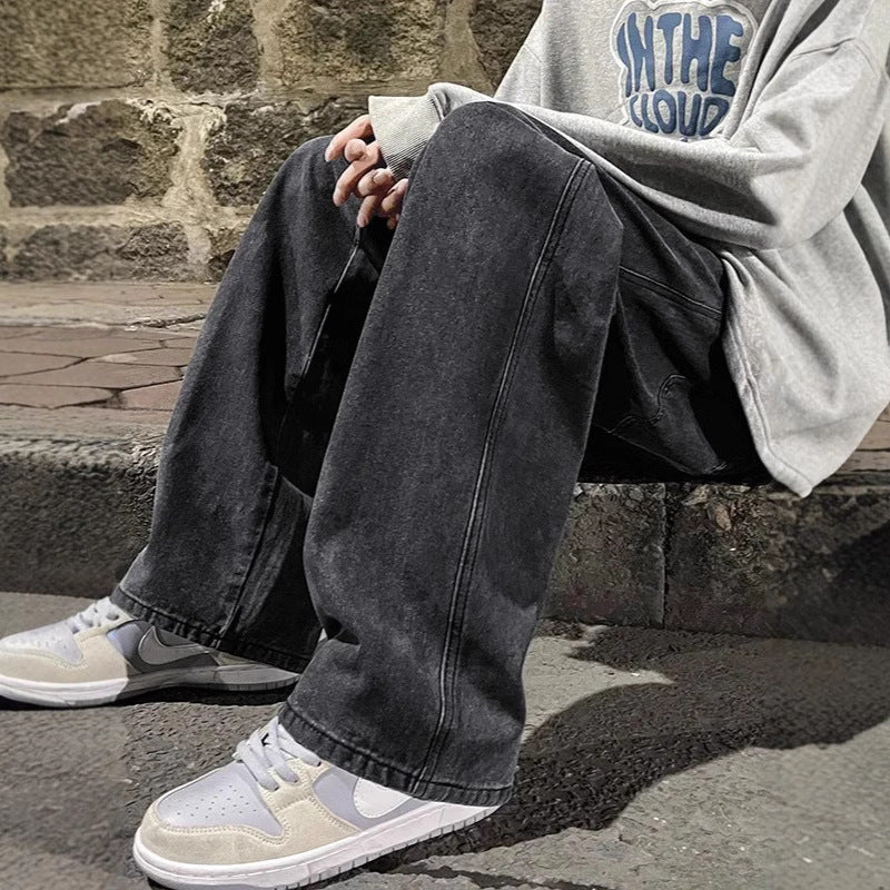 Person wearing dark jeans and light-colored sneakers sitting on a stone step.