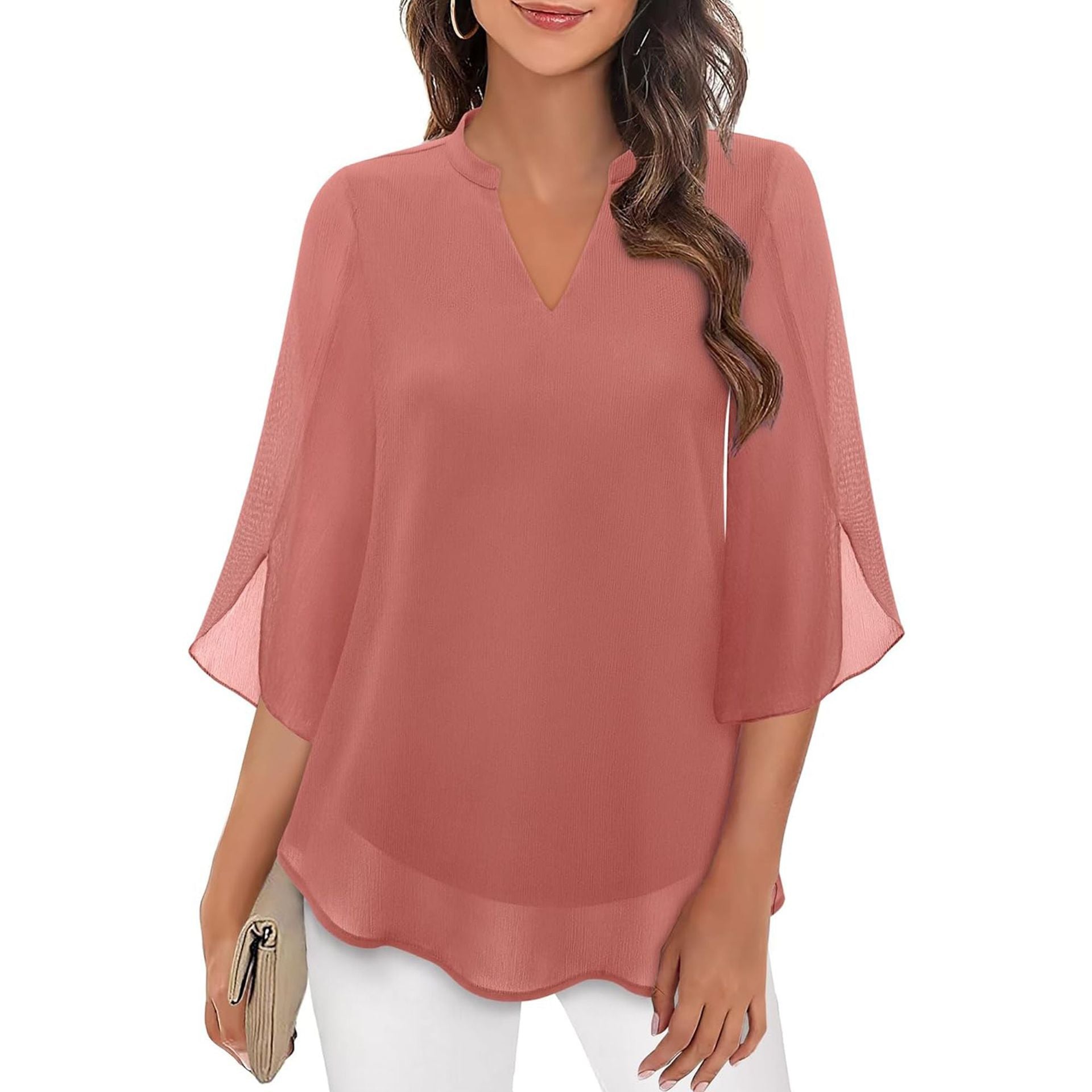 Woman wearing a pink blouse with sheer sleeves on a white background