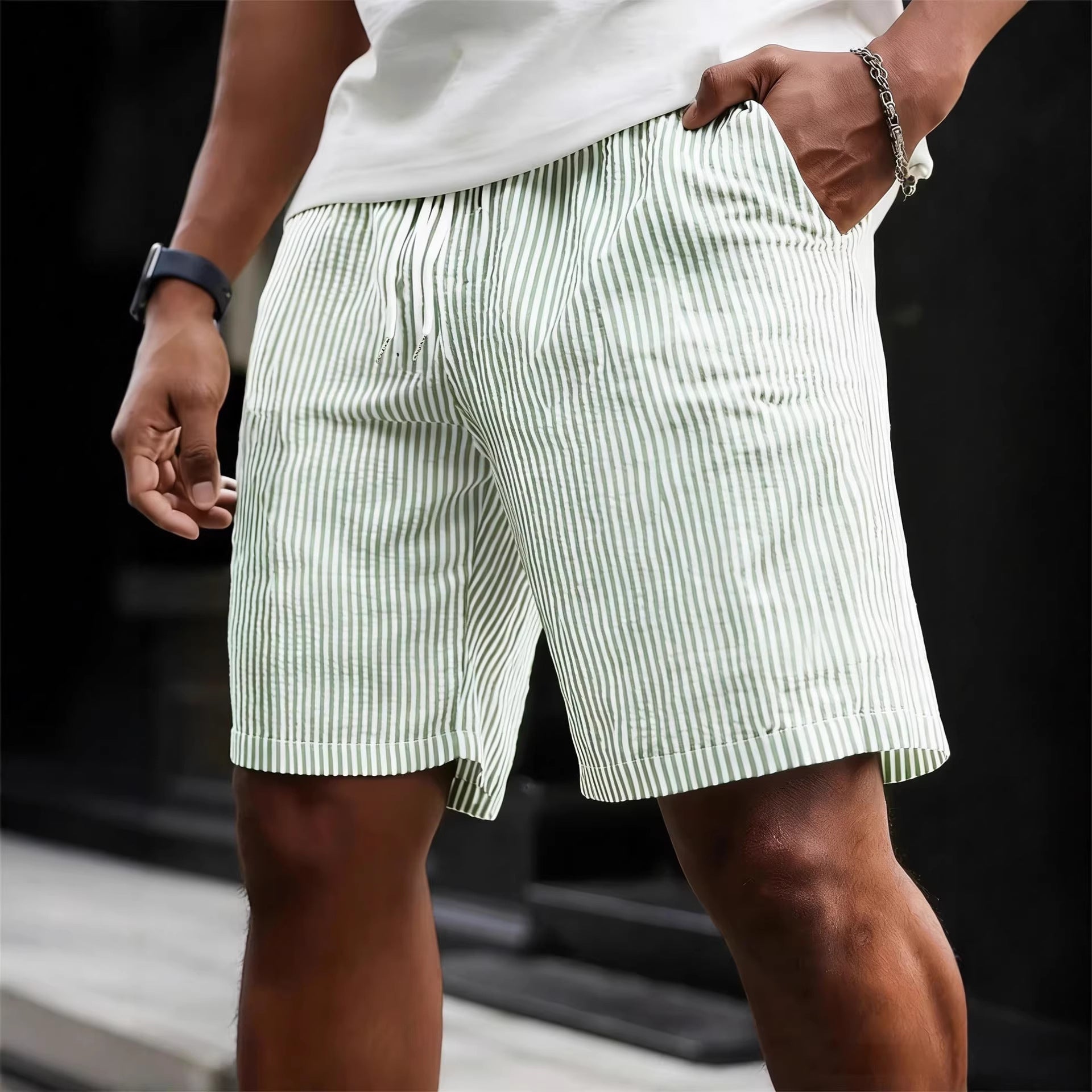 Person wearing green and white striped shorts with a blurred background