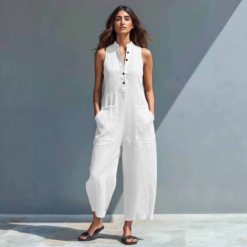 Woman wearing a white sleeveless jumpsuit against a gray background
