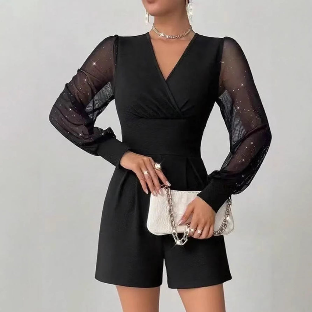 Black romper with sheer sleeves worn by a model on a light gray background