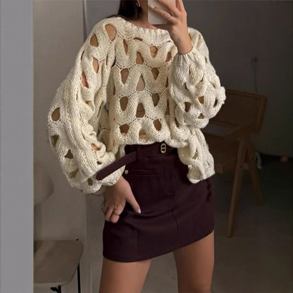Person wearing a textured beige sweater and dark skirt indoors.