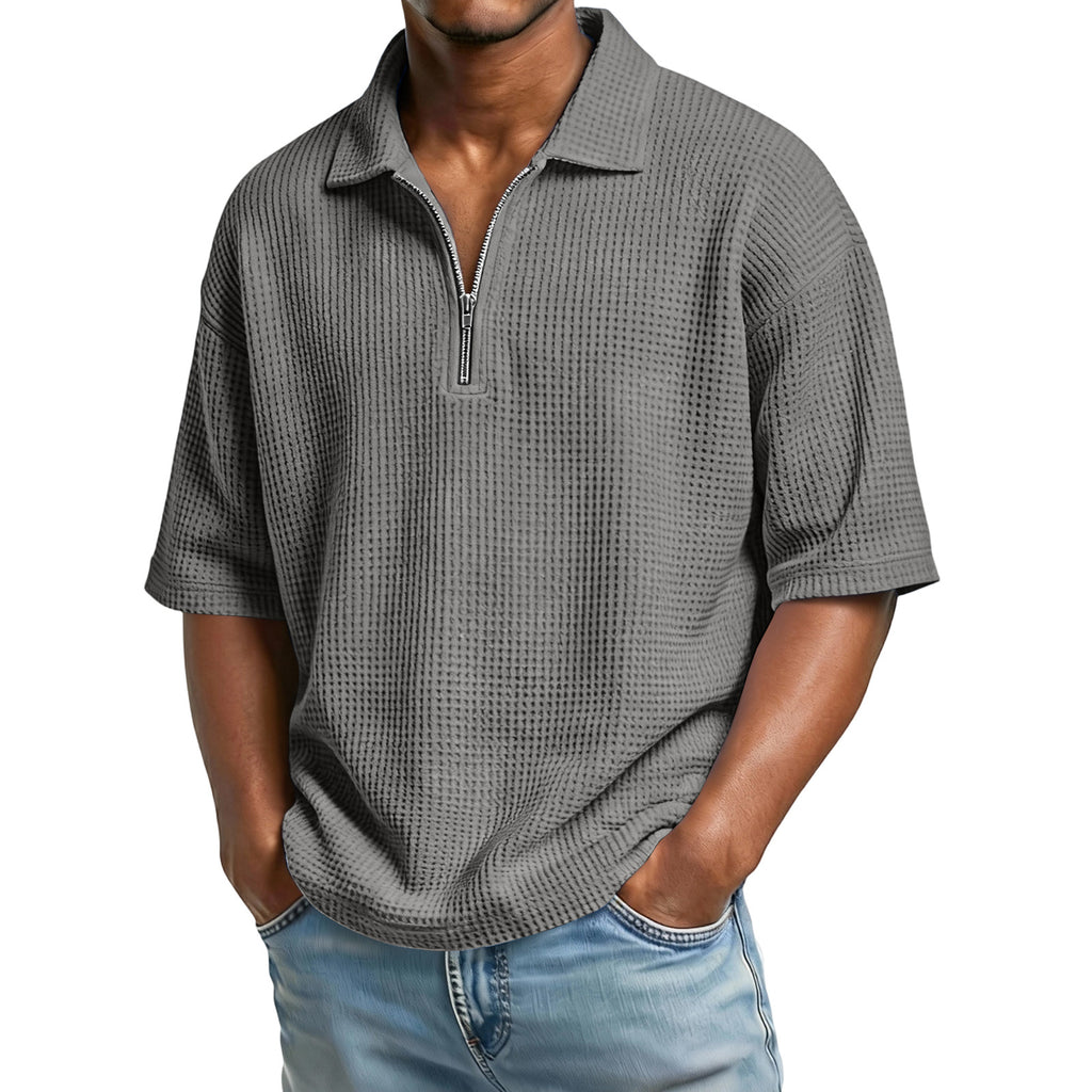 Man wearing a gray textured short-sleeve shirt with a zipper on a white background