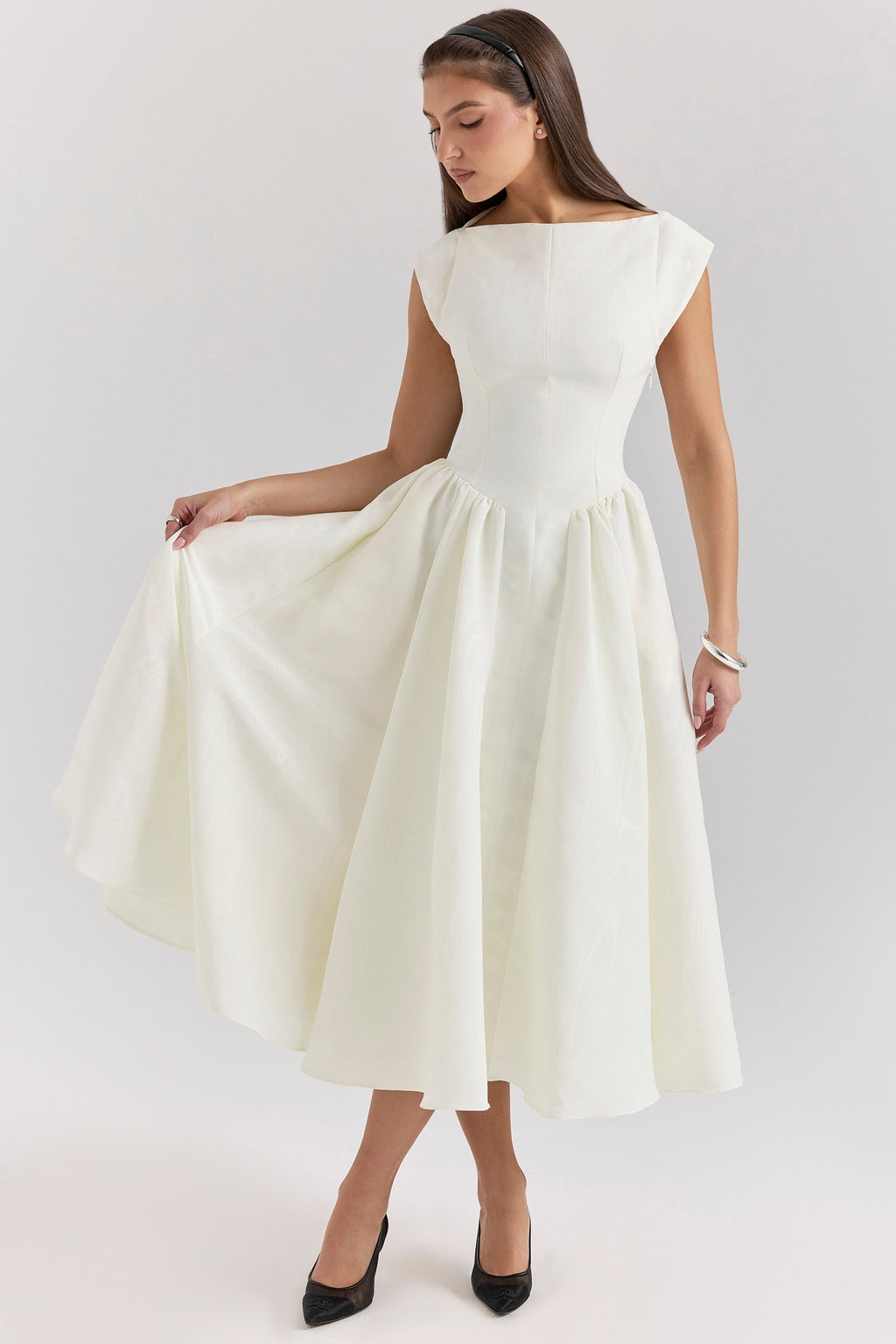 Woman wearing a white dress on a plain background