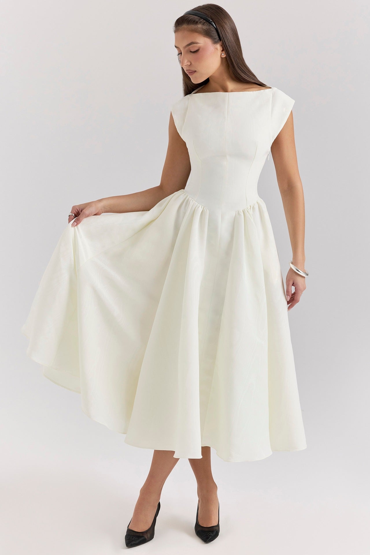 Woman wearing a white dress on a plain background