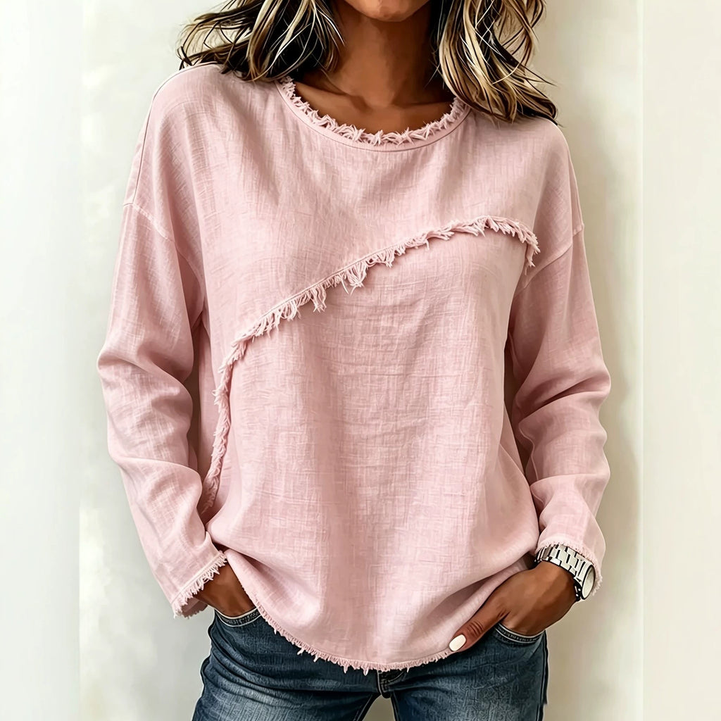 Person wearing a pink distressed sweatshirt with a plain background