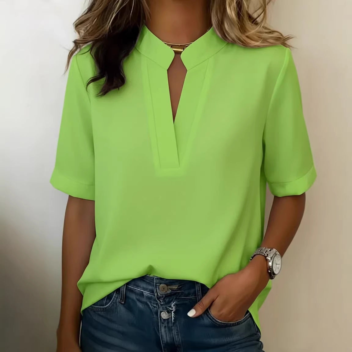 Person wearing a bright green polo shirt with a plain background