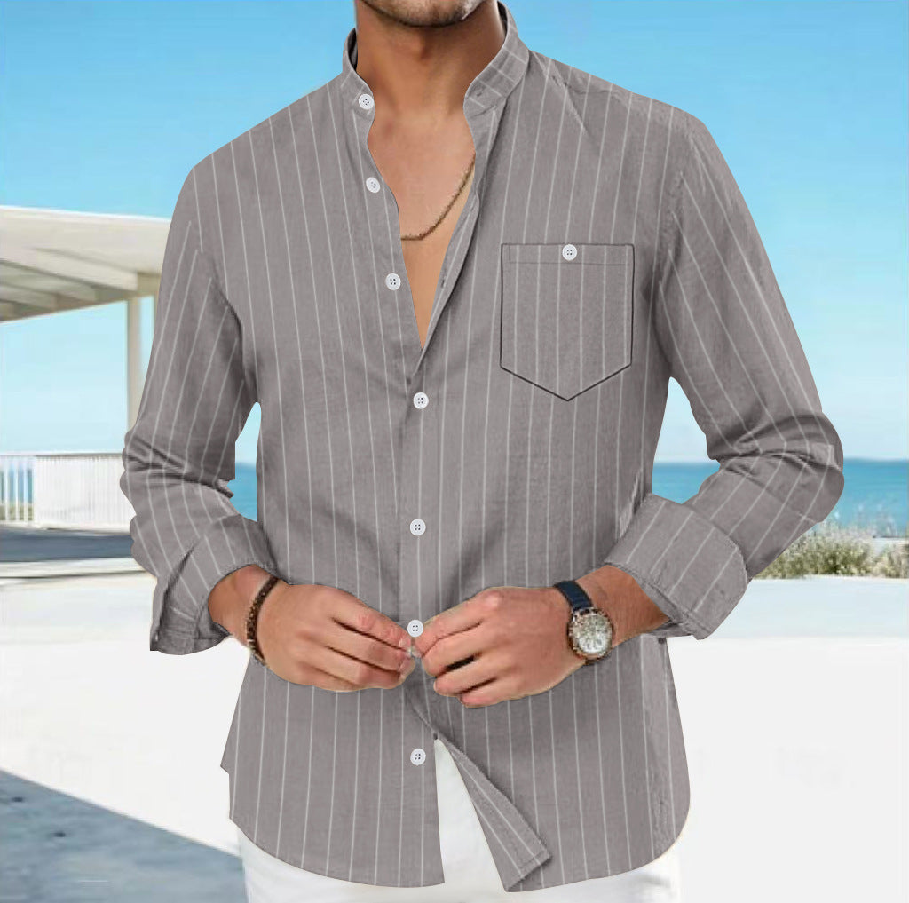 Man wearing a gray pinstripe shirt with a blurred background of a pool and blue sky.