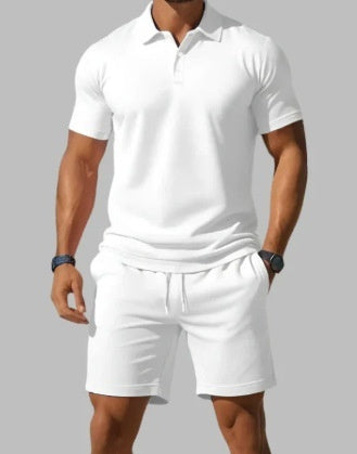 Person wearing a white polo shirt and shorts on a gray background