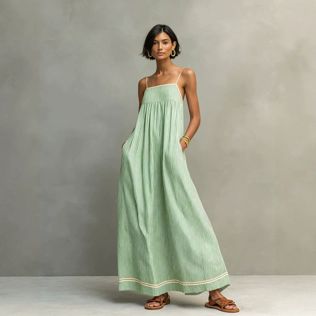 Woman wearing a green striped dress against a gray background