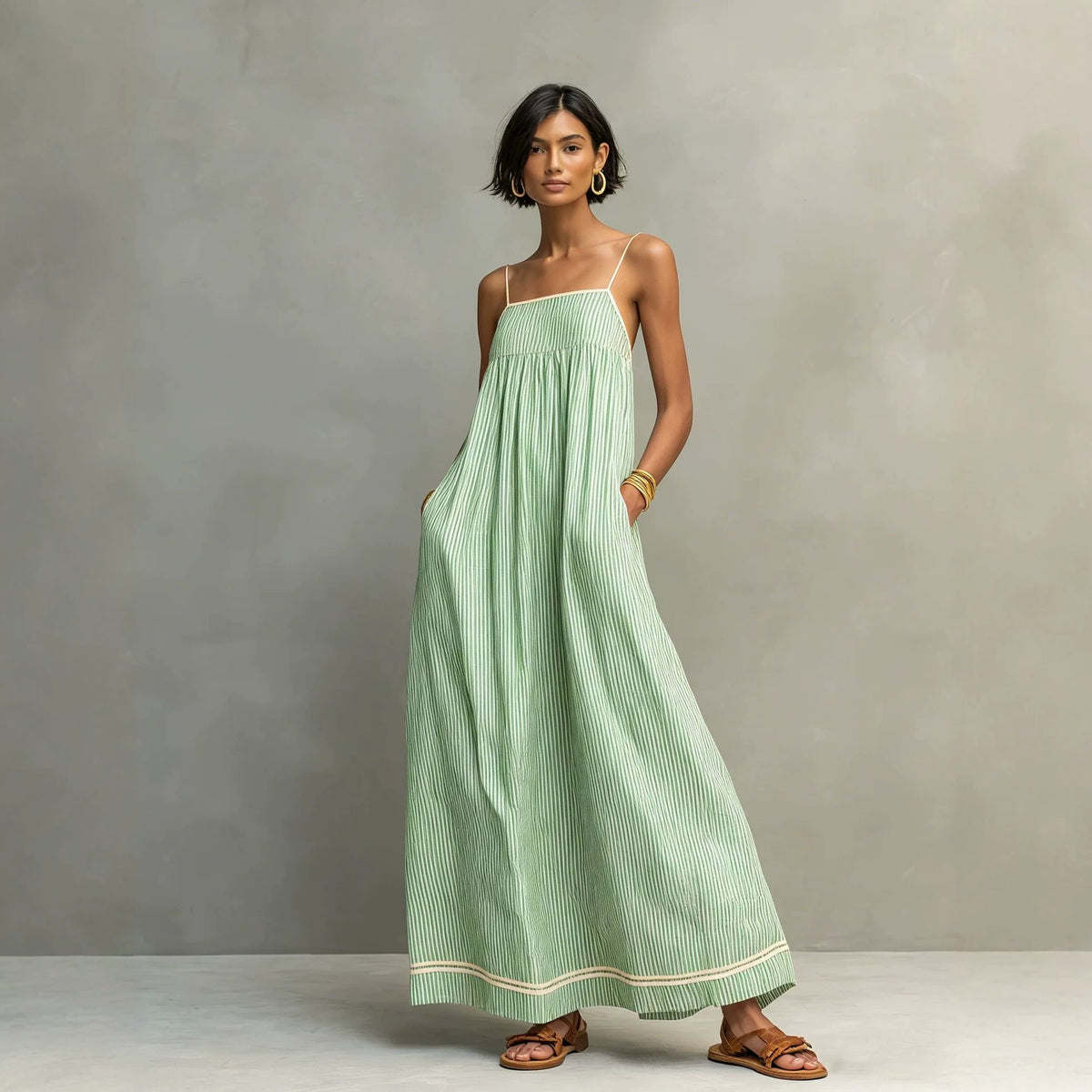 Woman wearing a green striped dress against a gray background