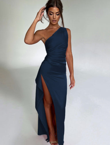 Woman wearing a one-shoulder navy blue dress with a slit on a white background