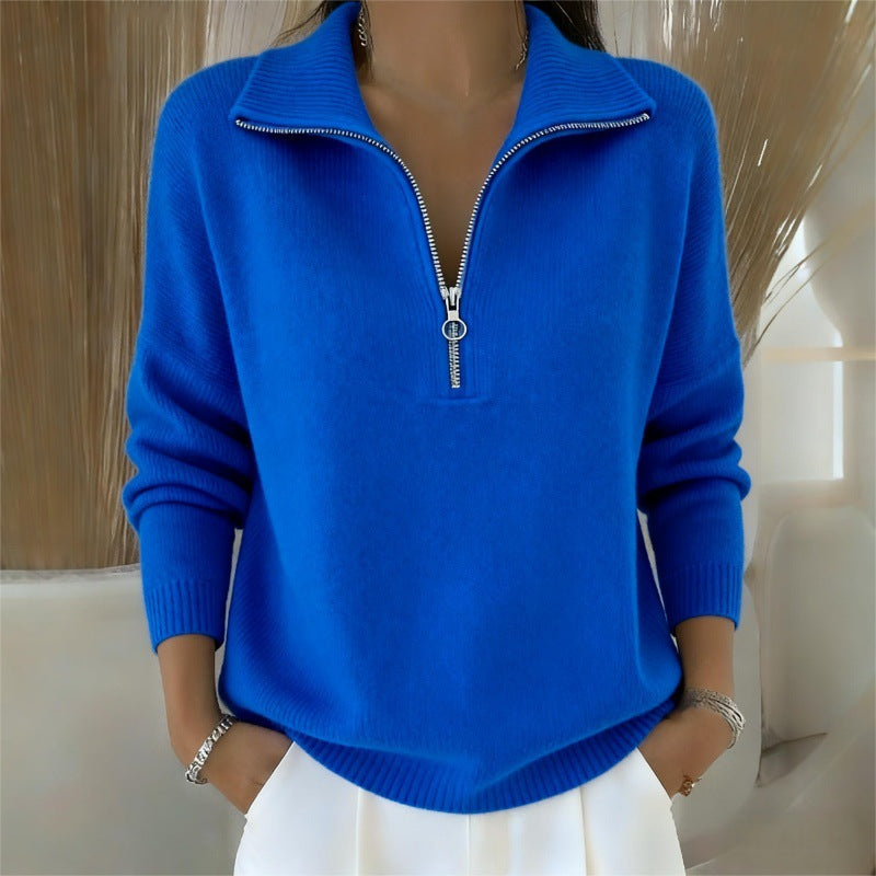 Blue zip-up sweater worn by a person against a neutral background