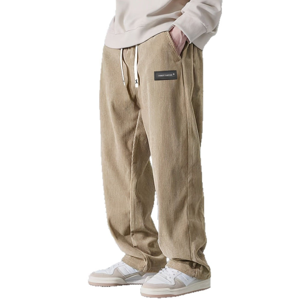 Beige corduroy pants worn by a person on a white background