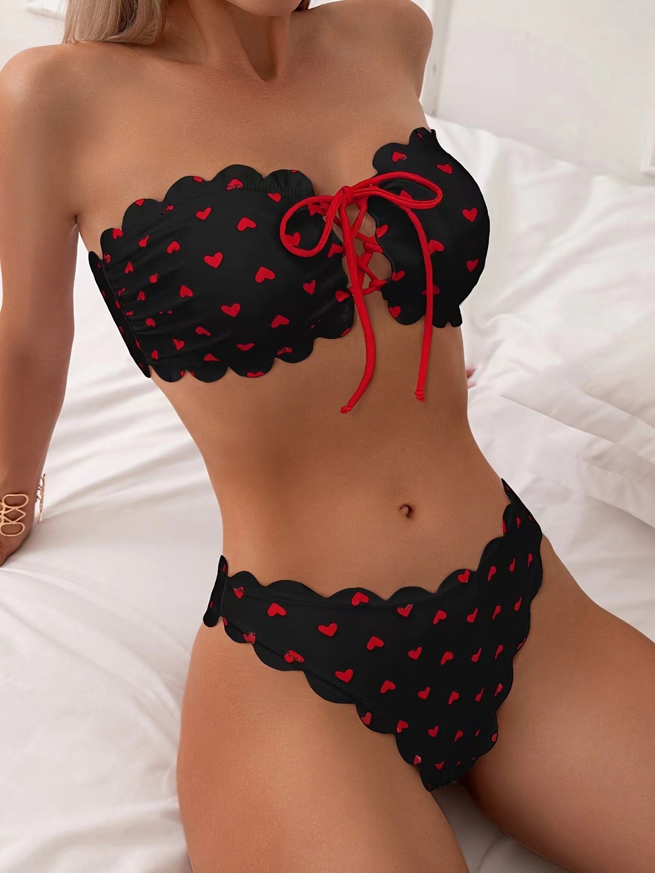 Black bikini with red heart patterns on a white background