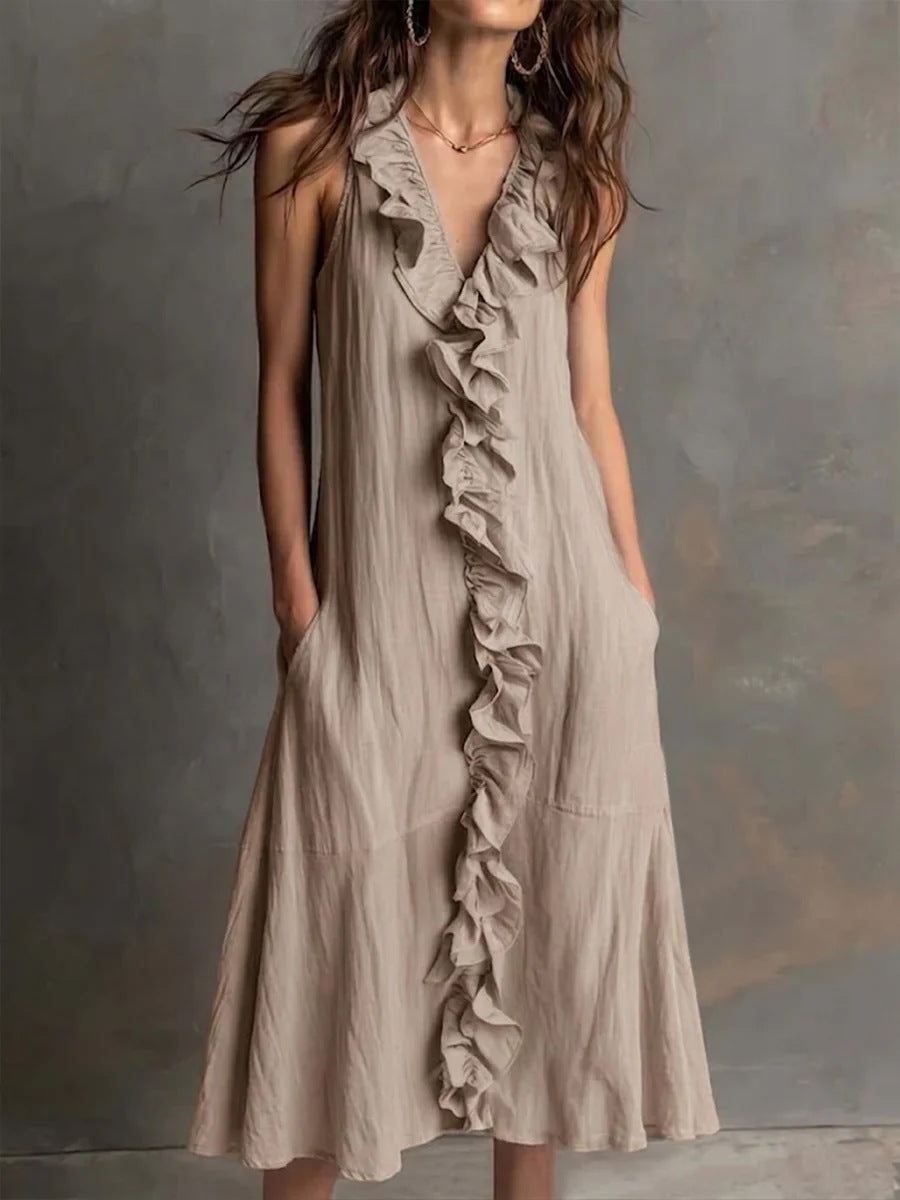 Woman wearing a beige ruffled dress against a gray background