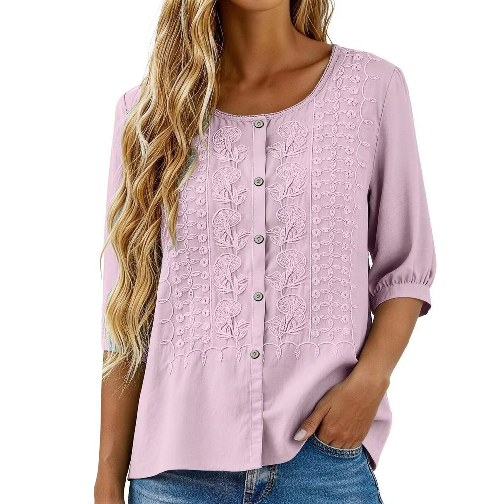 Light pink blouse with floral embroidery on a white background