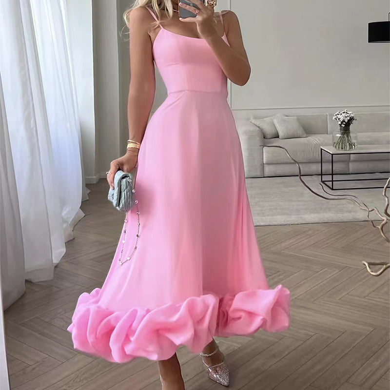 Woman in a pink dress taking a mirror selfie in a modern living room.