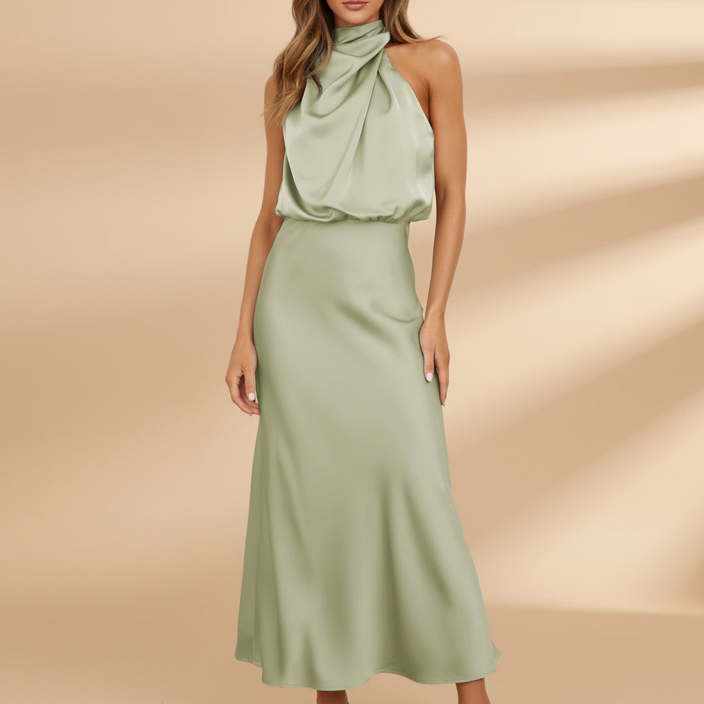 Woman wearing a green halter neck dress against a white background