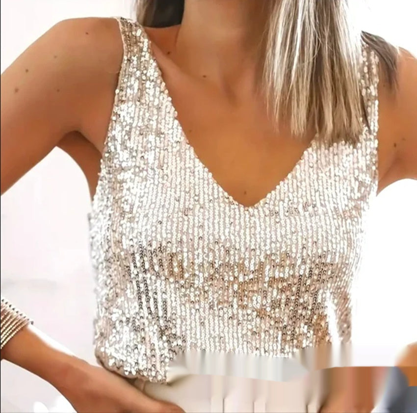 Close-up of a person wearing a sparkly silver top with a blurred background
