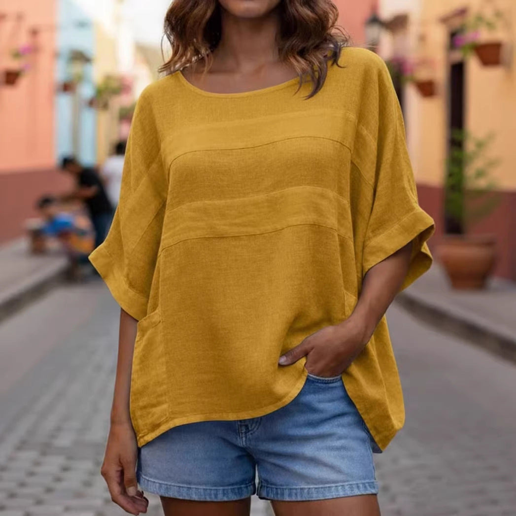 Person wearing a yellow oversized shirt and denim shorts on a street background