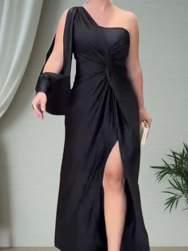 Black one-shoulder dress with a slit on a neutral background
