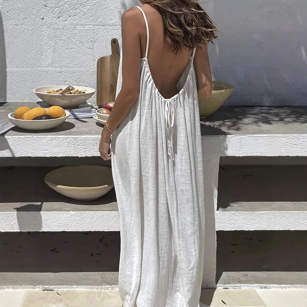 Woman in a white dress standing outdoors with a table and bowls in the background