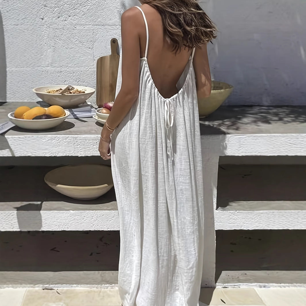 Woman in a white dress standing outdoors with a table and bowls in the background