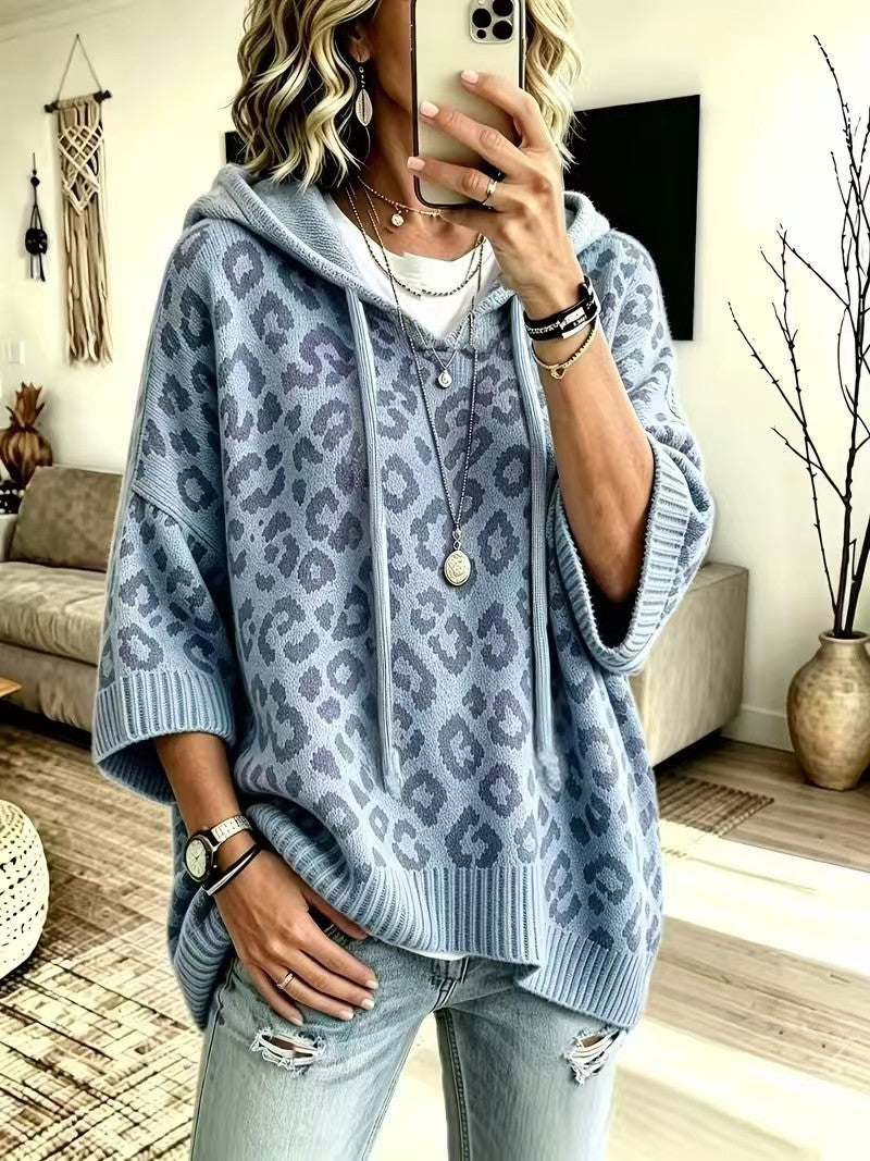 A woman takes a mirror selfie wearing a light blue and gray leopard-print knit hoodie with three-quarter sleeves, paired with light-wash distressed jeans.
