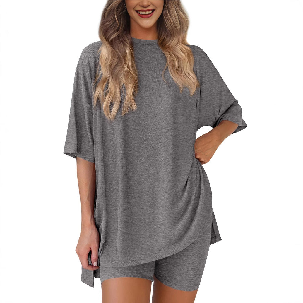 Woman wearing a gray oversized t-shirt and shorts set on a white background