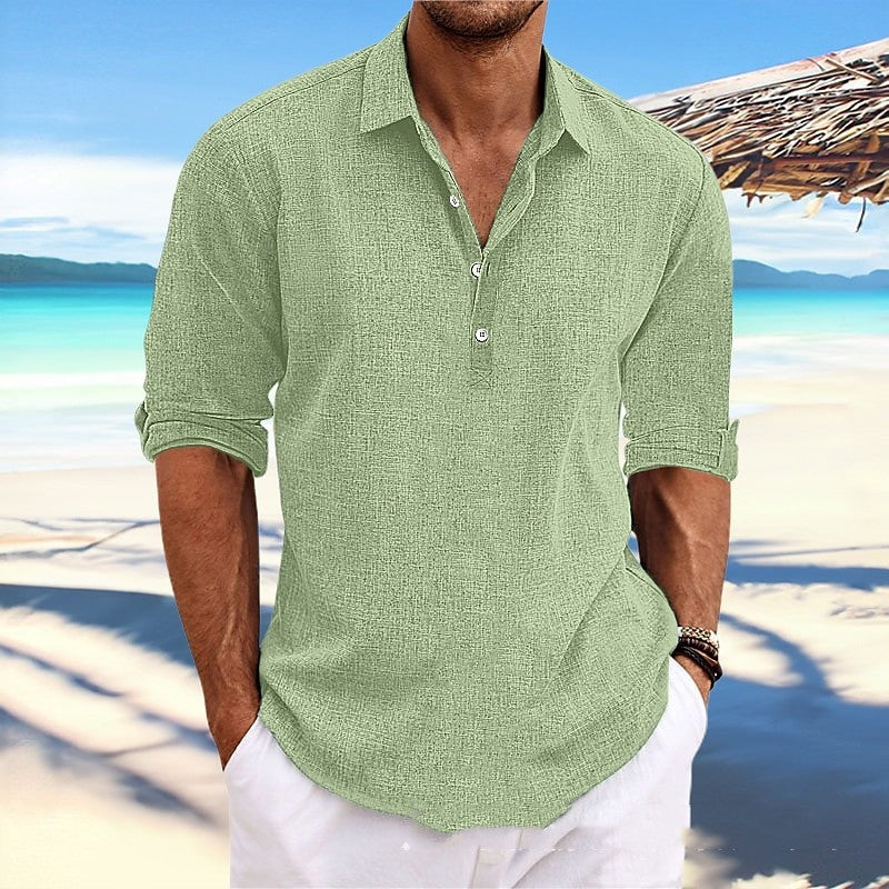 Man wearing a green shirt and white pants on a beach