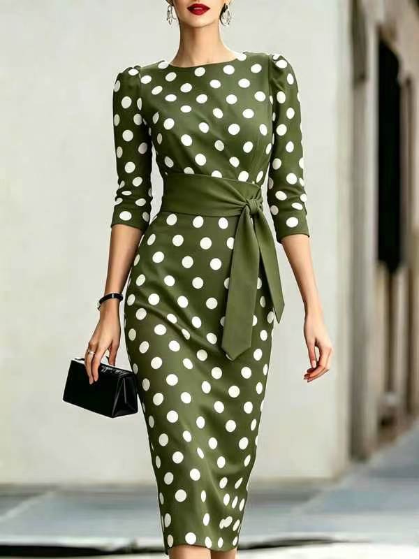 Green dress with white polka dots worn by a model against a neutral background