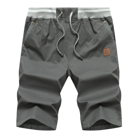 Gray shorts with a drawstring and brand patch on a white background