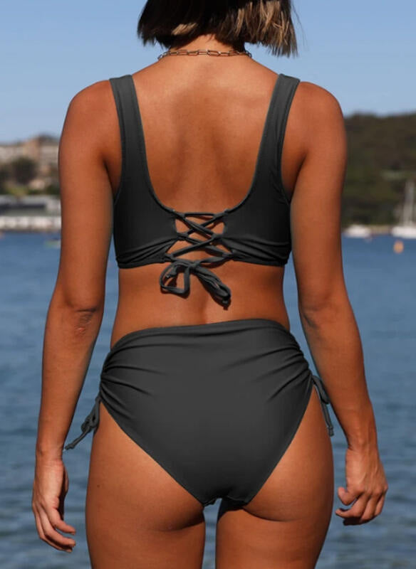 Person wearing a black bikini set with a blurred background of water and sky