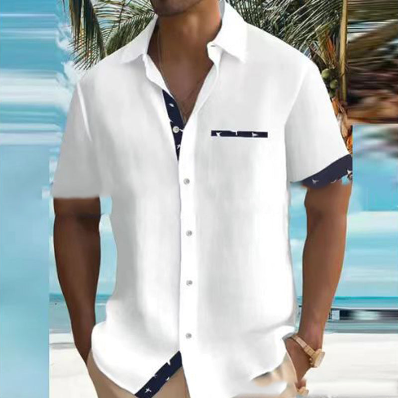 Person wearing a white short-sleeve shirt with blue accents by a poolside.