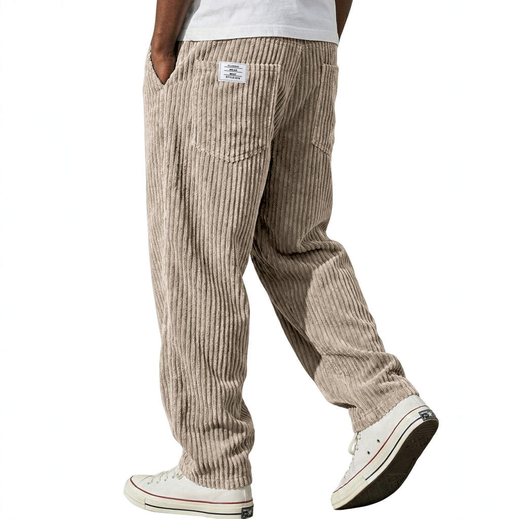 Beige corduroy pants worn by a person on a white background