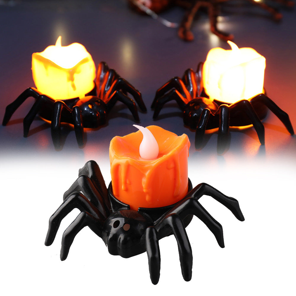 Spider-shaped candle holders with candles on a dark background