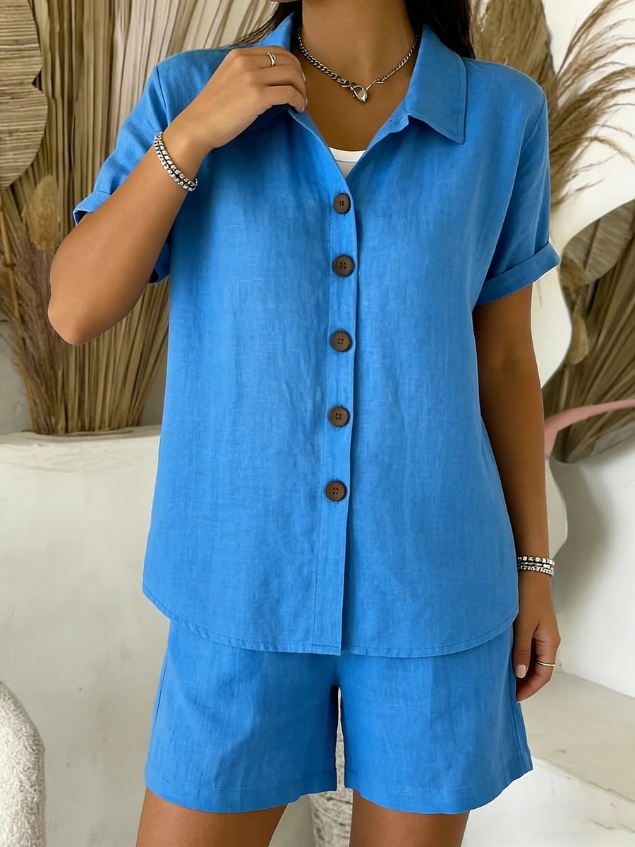 Person wearing a blue outfit with button details against a neutral background