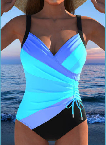 Woman wearing a blue and black swimsuit with a scenic background