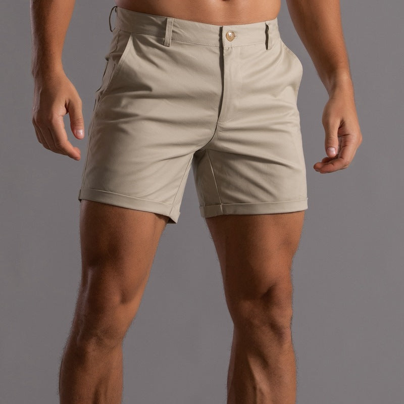 Beige shorts worn by a person on a gray background