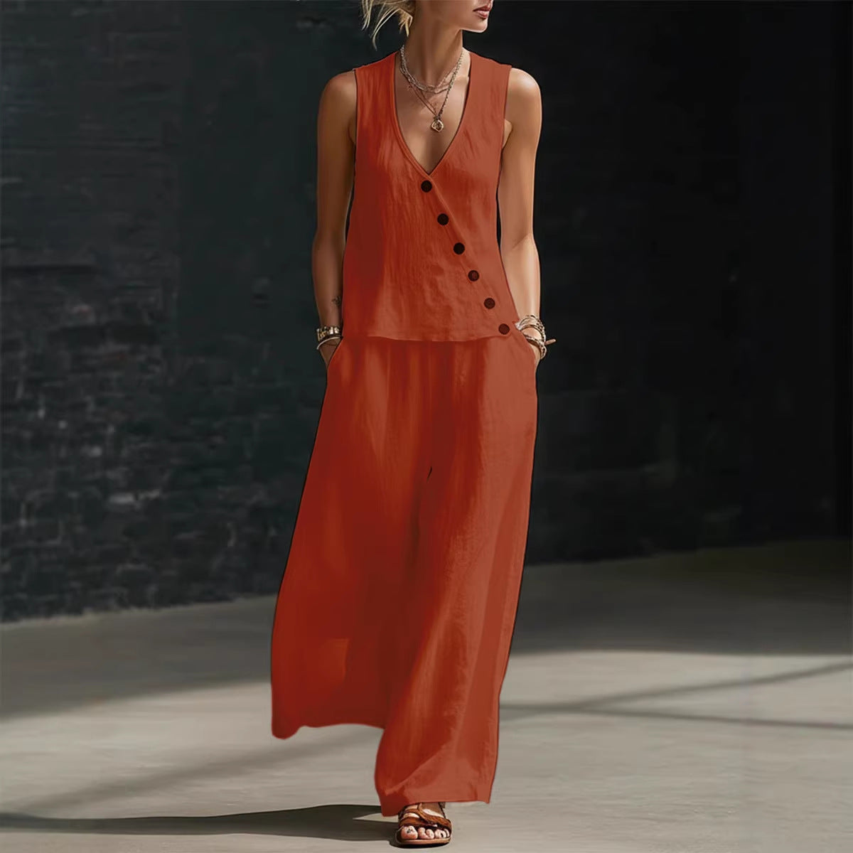Woman wearing a long orange dress against a dark background
