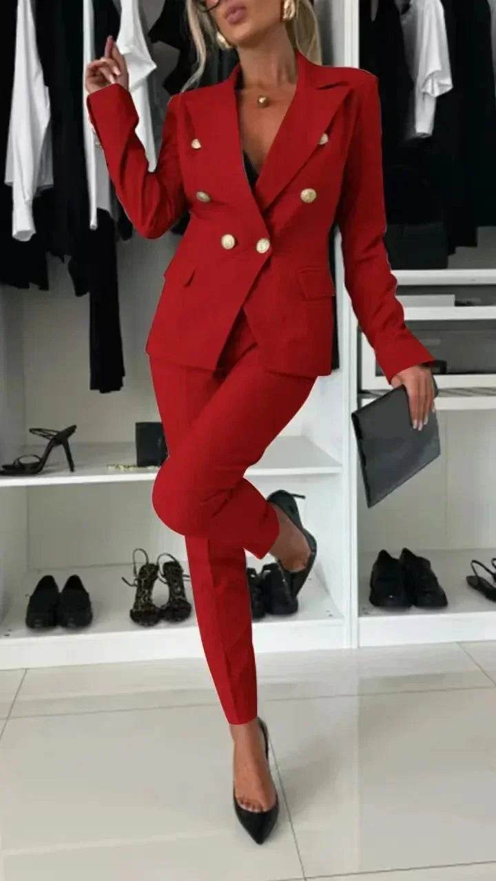 Woman in chic red blazer suit with gold buttons, black heels, clutch, in modern closet