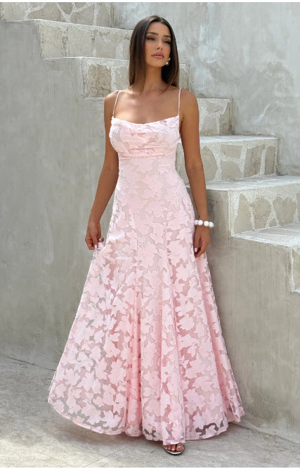 Woman in a pink floral dress standing on stone steps.