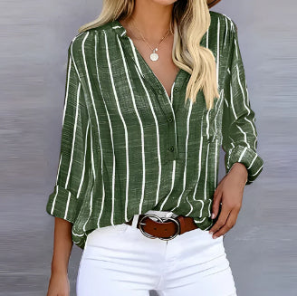 Person wearing a green and white striped shirt with a blurred background