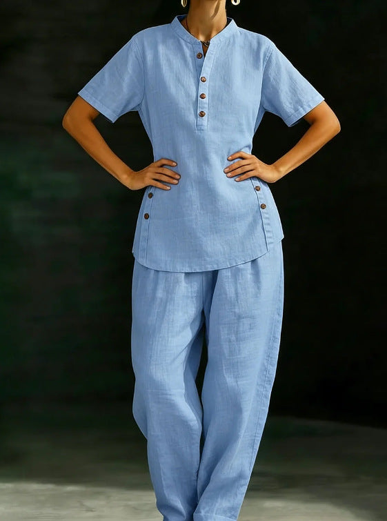 Person wearing a light blue outfit with buttons on a dark background