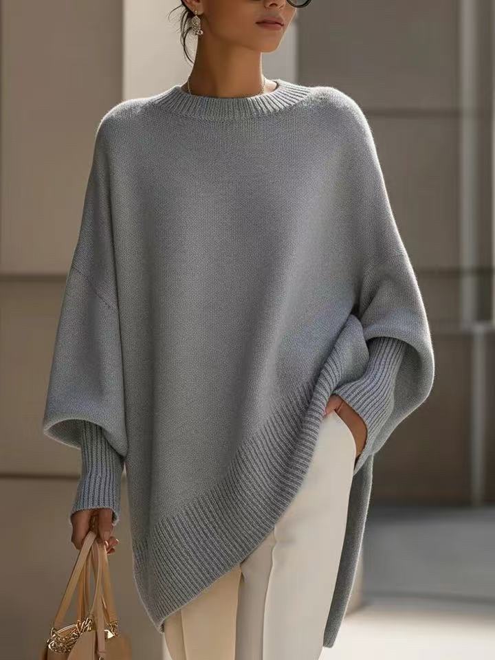 Person wearing a light blue poncho with a neutral background