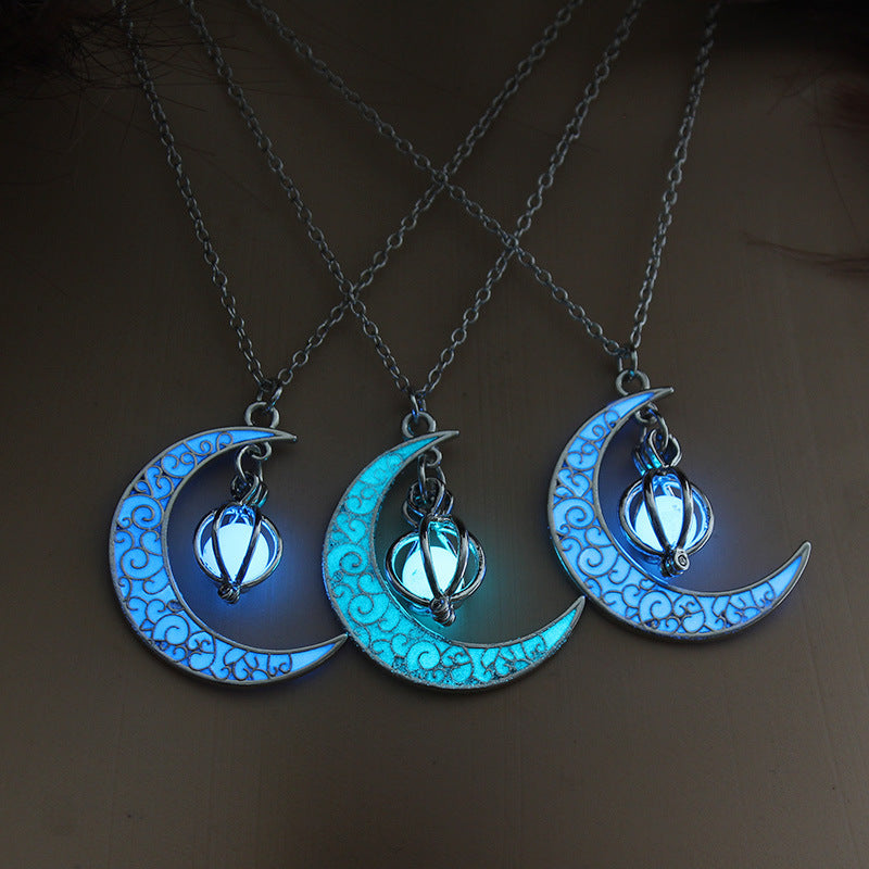 Three crescent moon necklaces with glowing blue designs on a dark background
