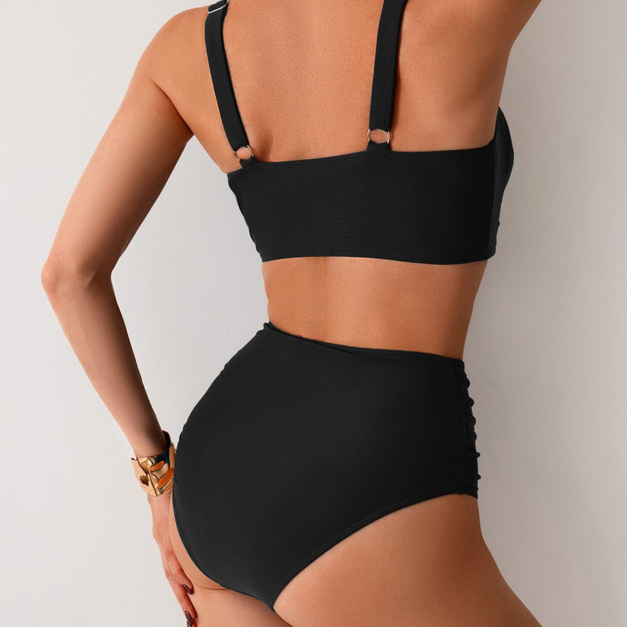 Black bikini worn by a person on a plain background