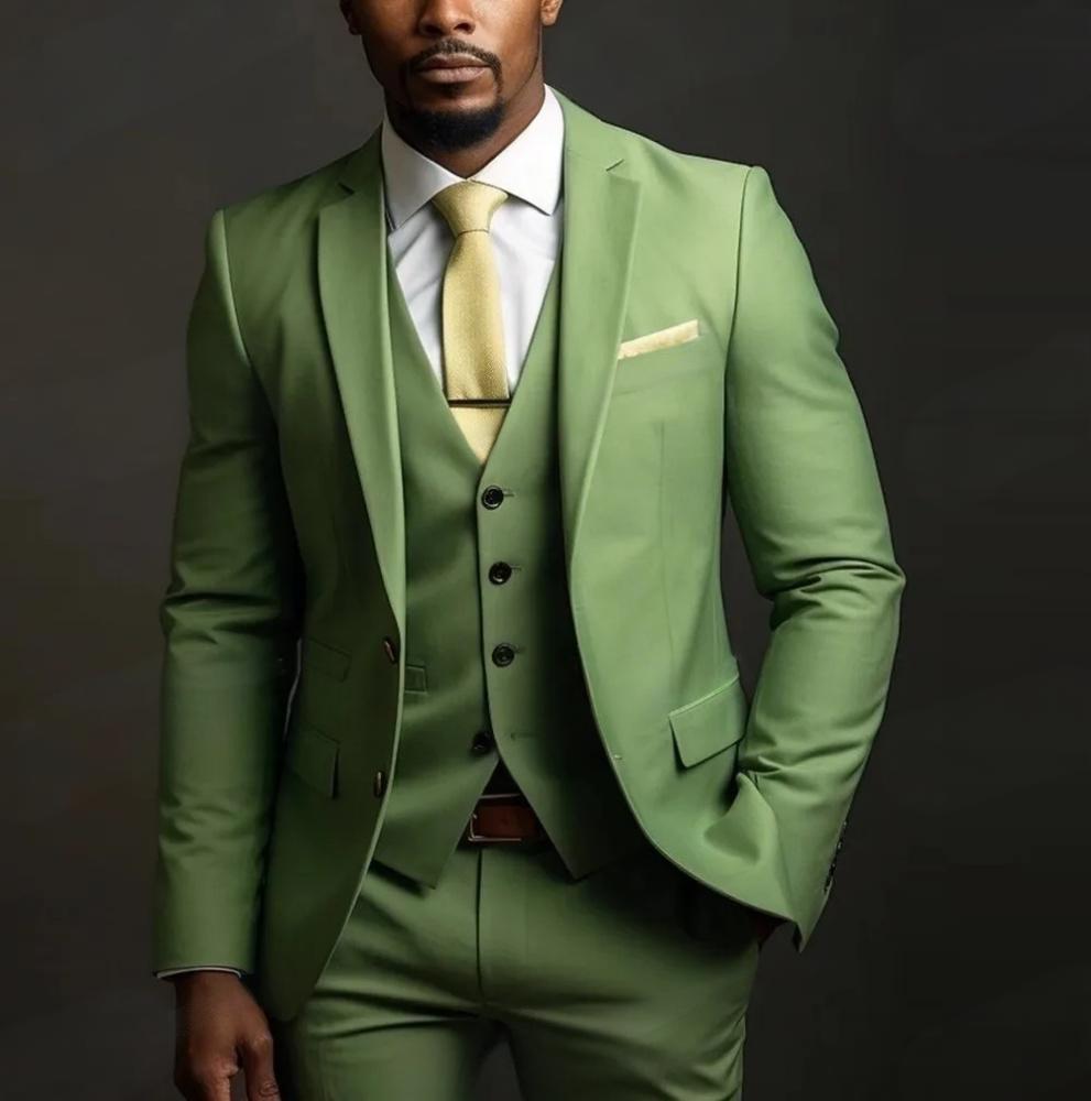 Man wearing a green suit with a white shirt and yellow tie on a dark background