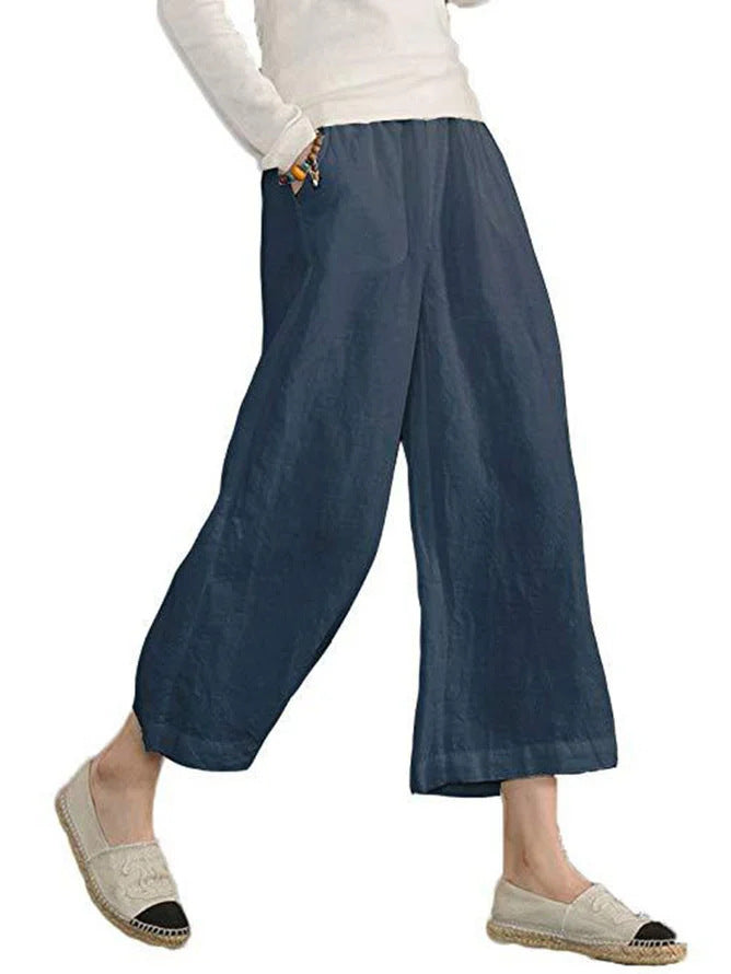 Person wearing blue wide-leg pants on a white background